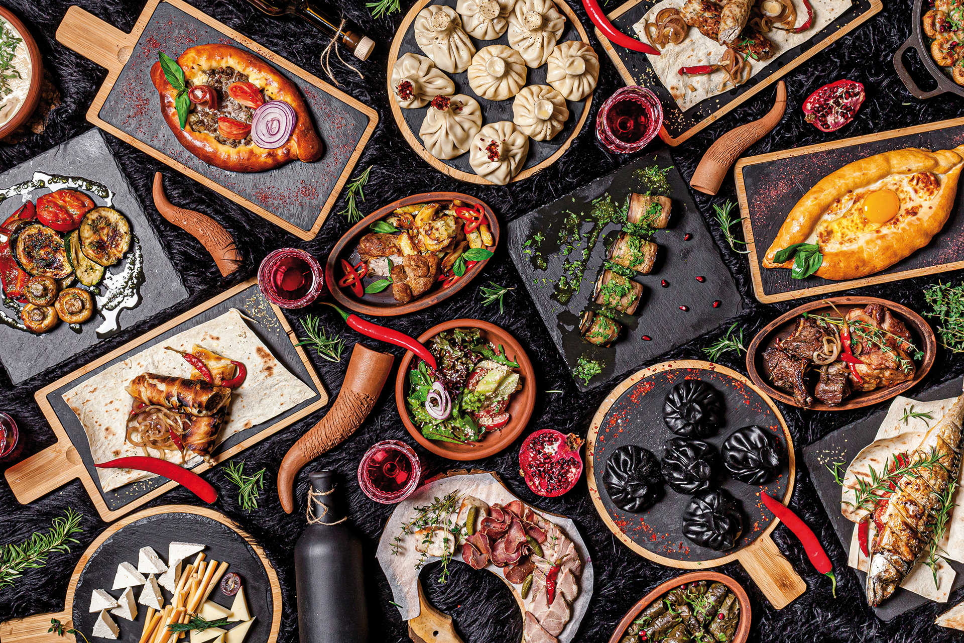 Vielfalt georgischer Spezialitäten mit Khinkali, Chatschapuri und Gemüseplatten