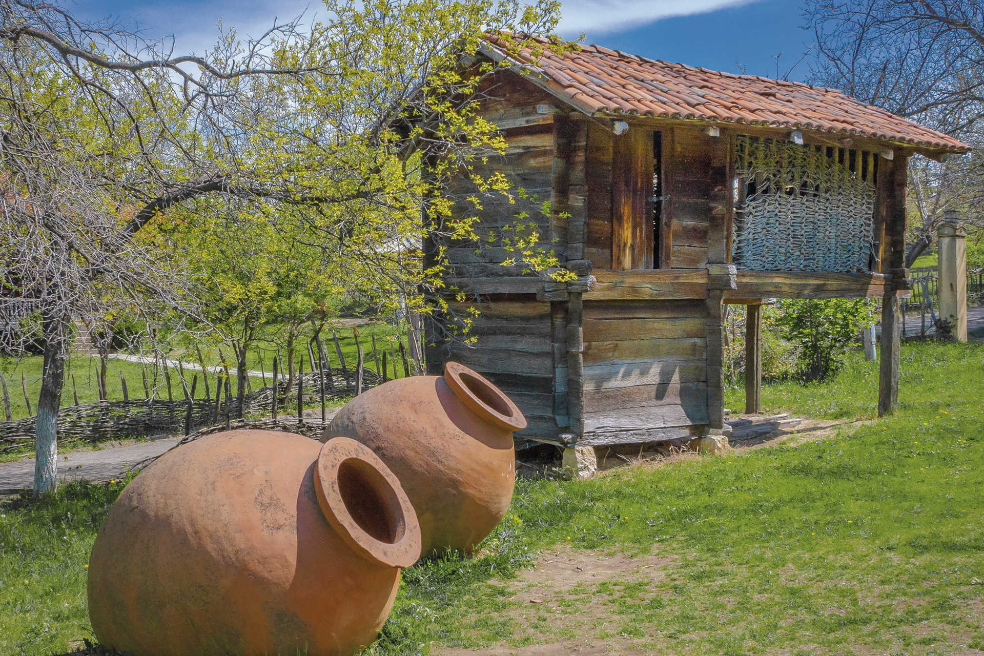 Traditionelle georgische Tonamphoren für Wein neben Holzspeicher im Grünen
