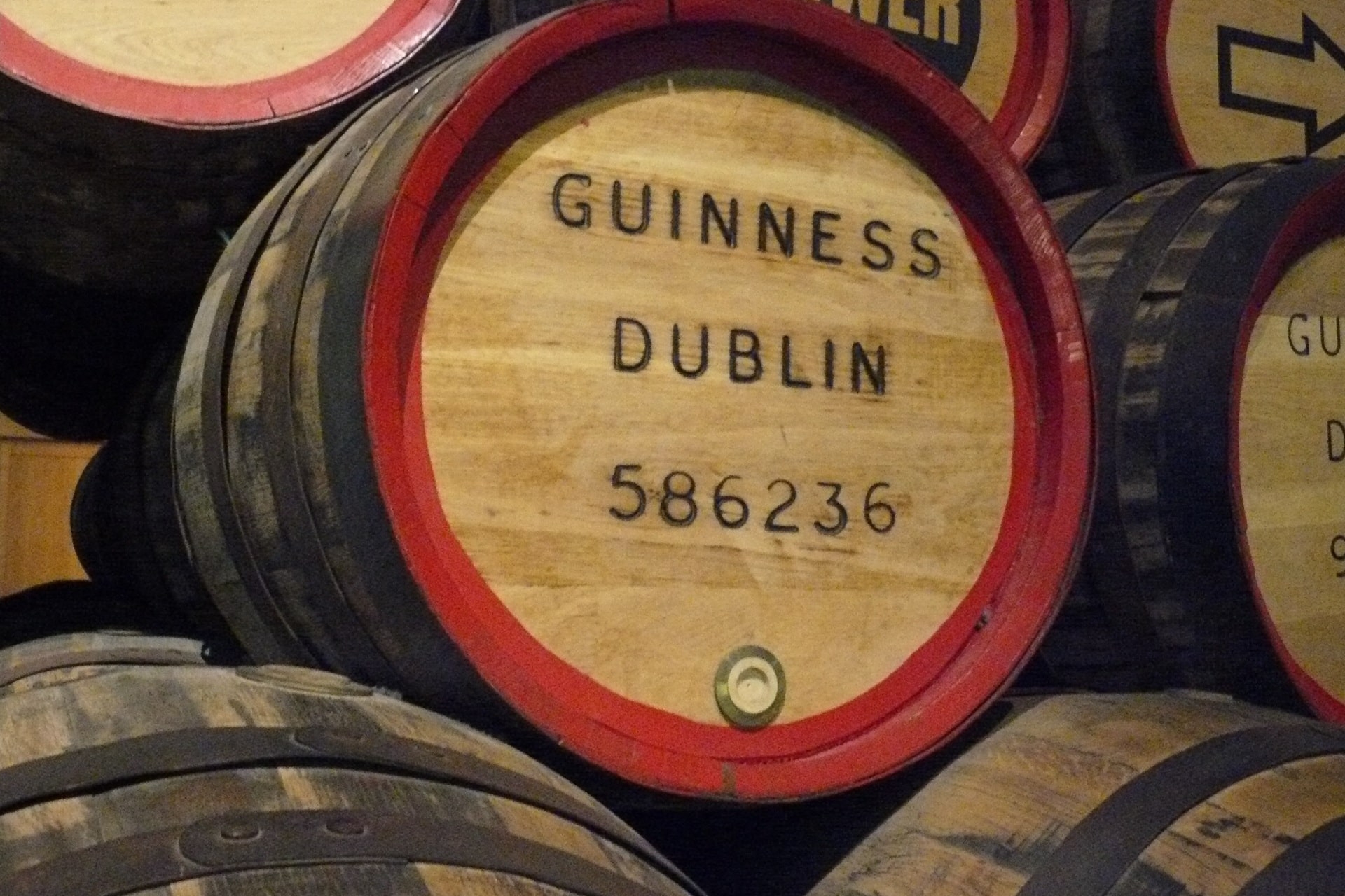 Holzfässer mit Guinness-Aufschrift in einer Brauerei gestapelt