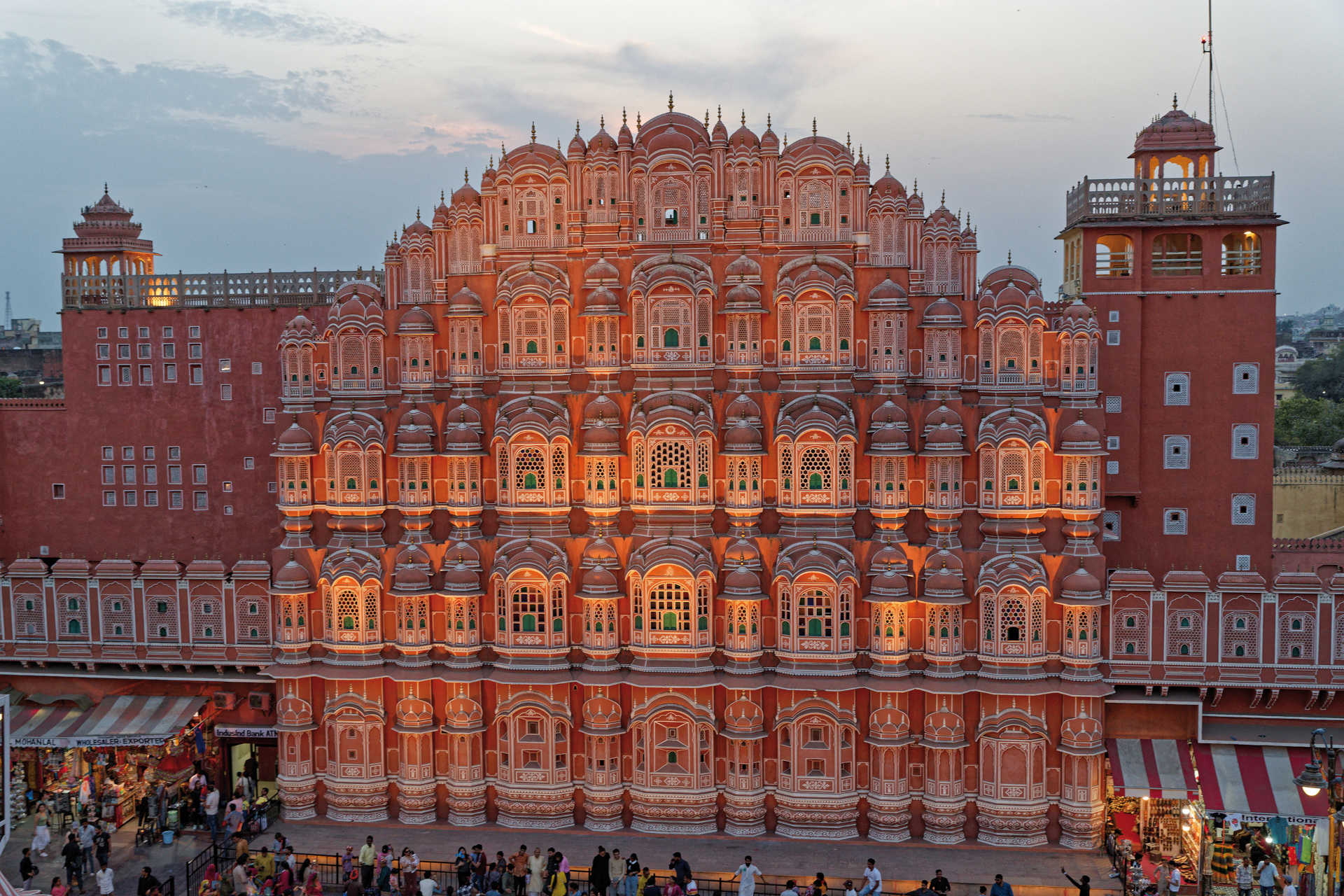 Fassade des Hawa Mahal mit zahlreichen kleinen Fenstern im Abendlicht in Jaipur