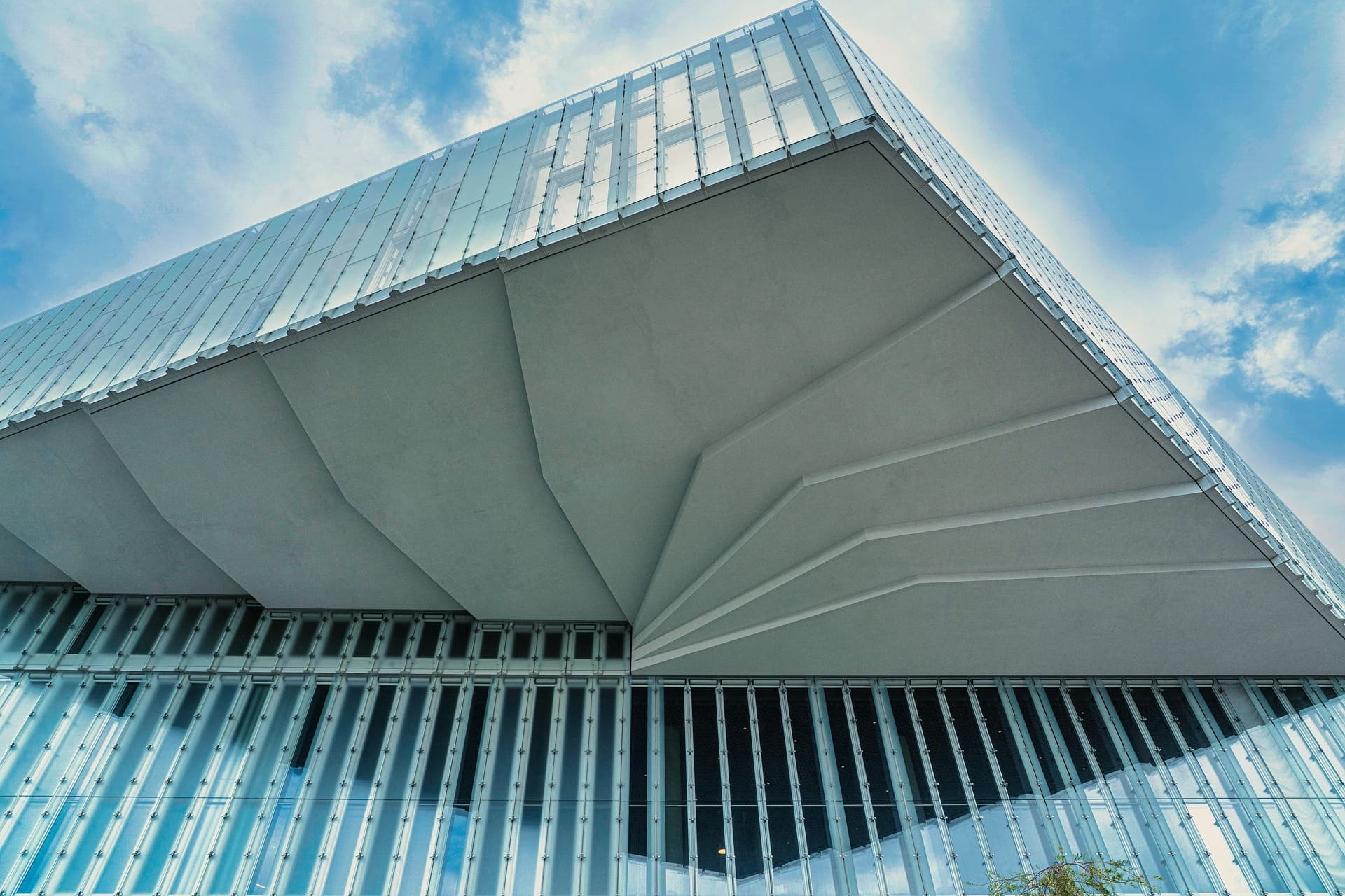 Futuristische Glasfassade mit markantem Dachvorsprung gegen Himmel