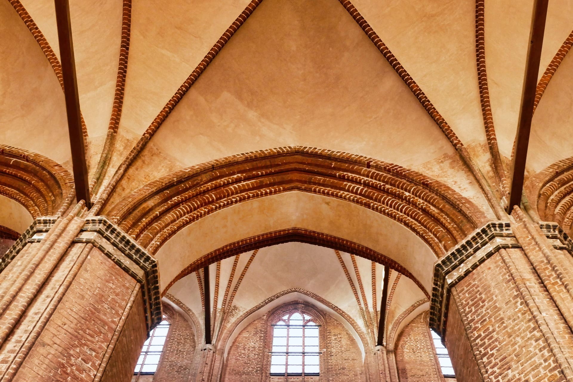 Backsteinpfeiler und Gewölbebögen in hoher gotischer Kirche
