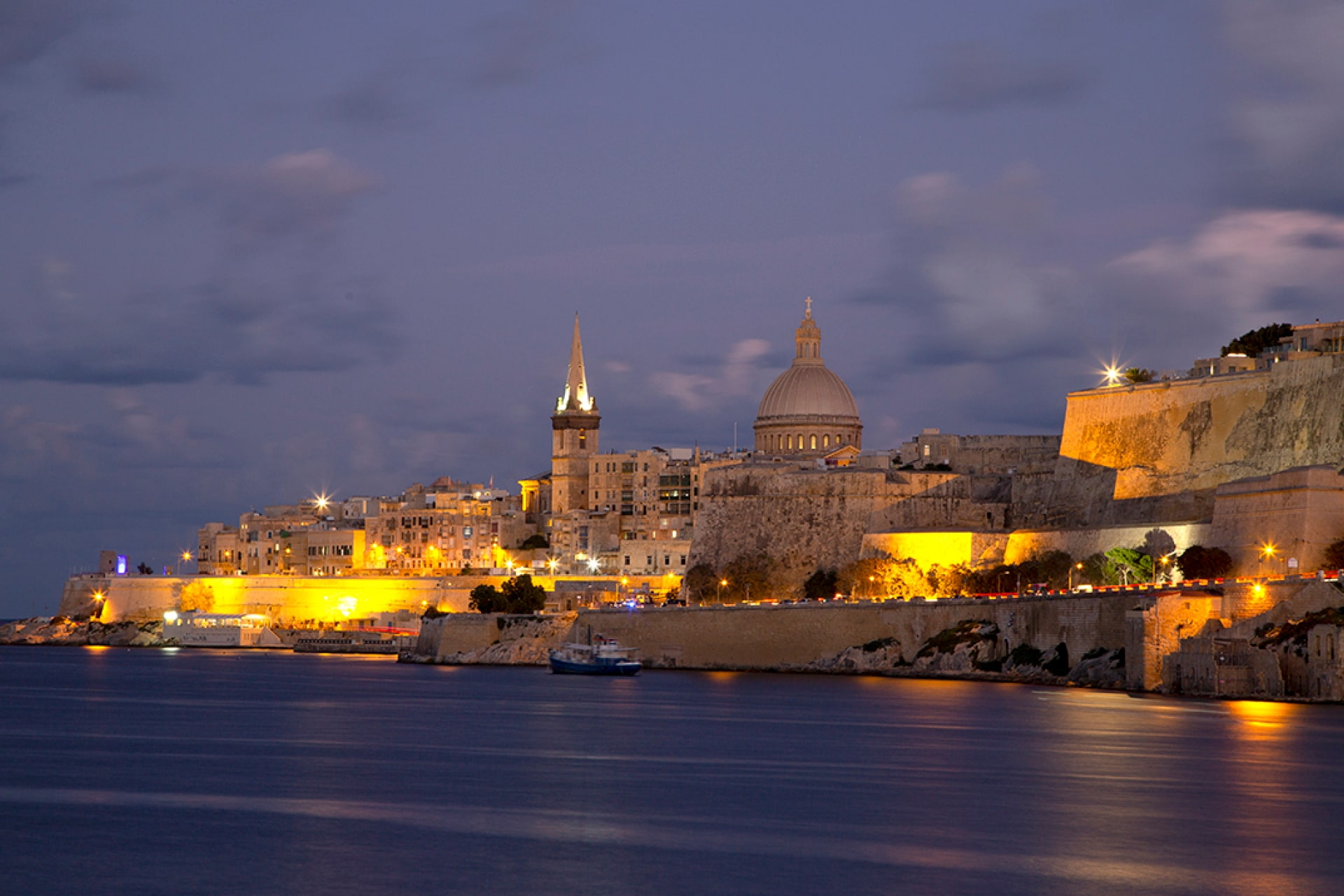 Beleuchtete Altstadt von Valletta auf Malta bei Sonnenuntergang mit Blick auf Kuppeln und Hafen