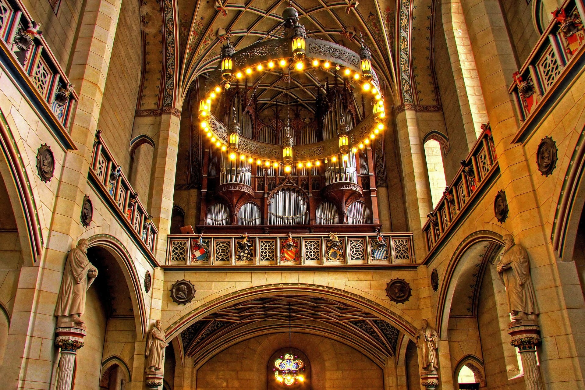Große Orgel mit Rundleuchter und gotischen Verzierungen im Kirchensaal