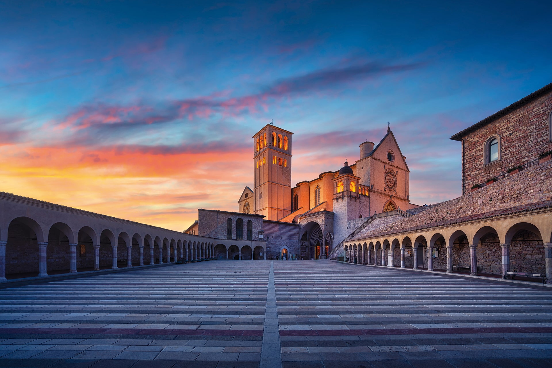 Großer Arkadenhof mit Kirche im Abendlicht