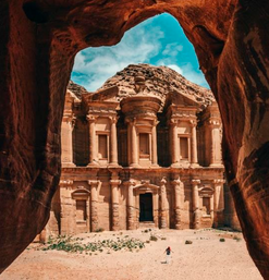 Monumentales Felsengebäude in Petra eingerahmt von rotem Gestein