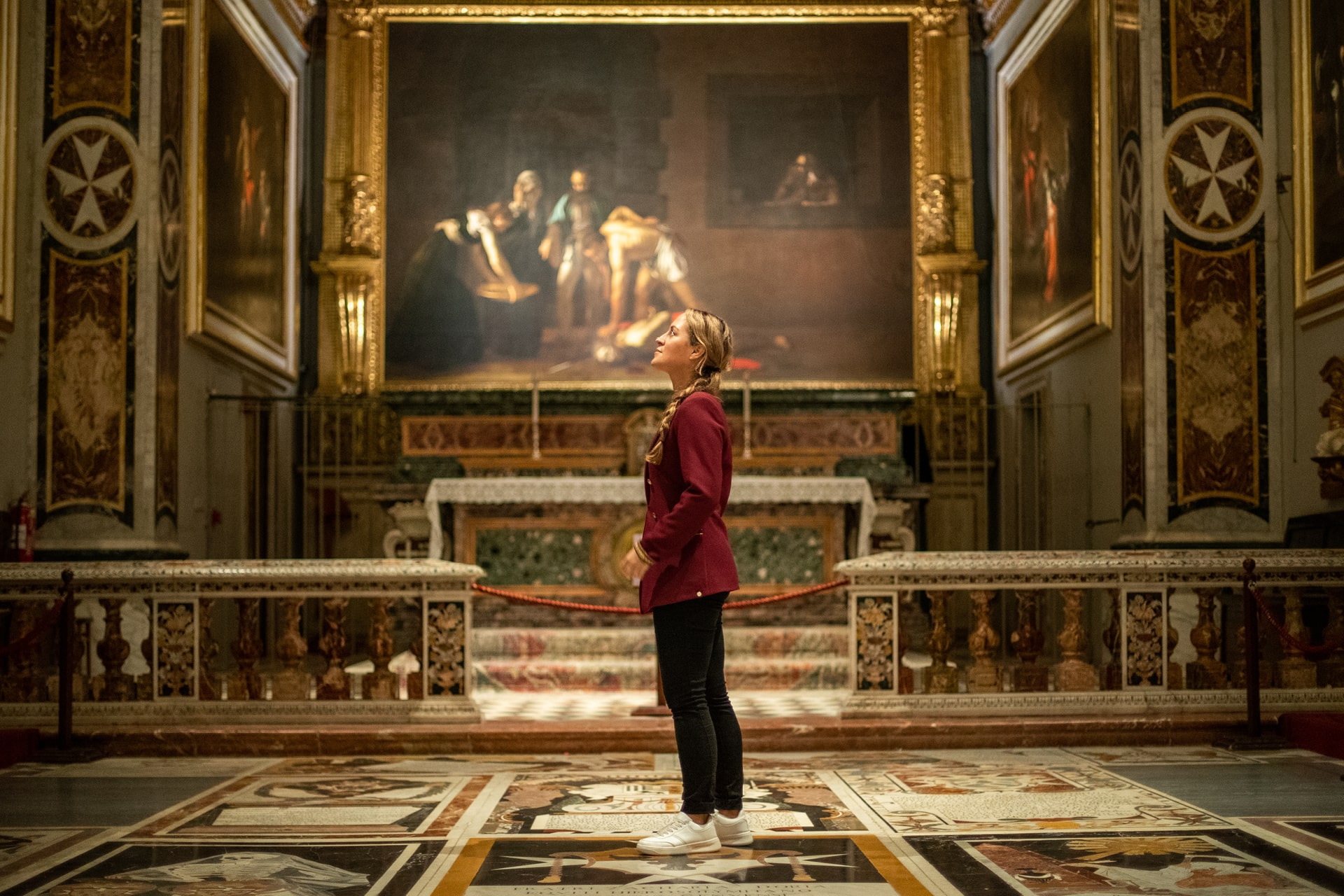 Besucherin betrachtet Caravaggio-Gemälde in der St. John’s Co-Kathedrale