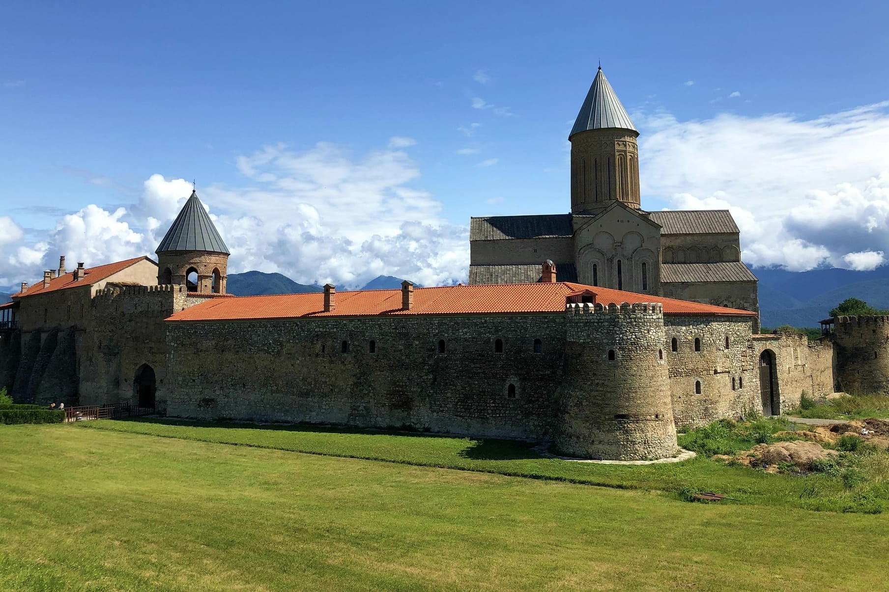 Steinerne Klosteranlage mit Türmen und rotem Ziegeldach