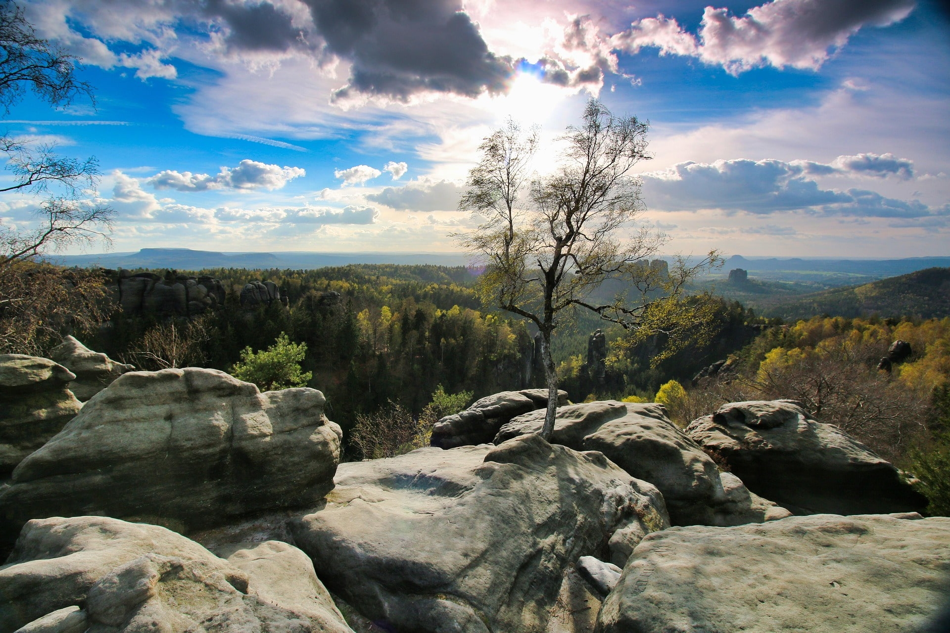 Aussicht von Felsen über Wälder und Hügel unter dramatischem Himmel