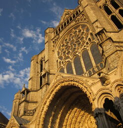 Westfassade mit Rosettenfenster und Figurenportal im Licht der Abendsonne