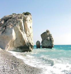Große Küstenfelsen im türkisfarbenen Meer bei sonnigem Wetter und Kiesstrand