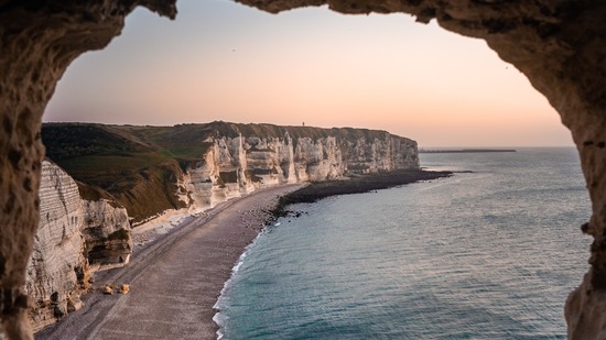 Blick durch Felsöffnung auf steile Kreideküste bei Sonnenuntergang
