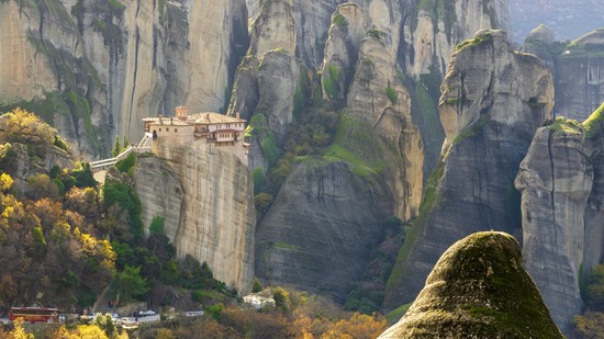 Mächtige Felsen tragen ein Kloster hoch über grünem Tal
