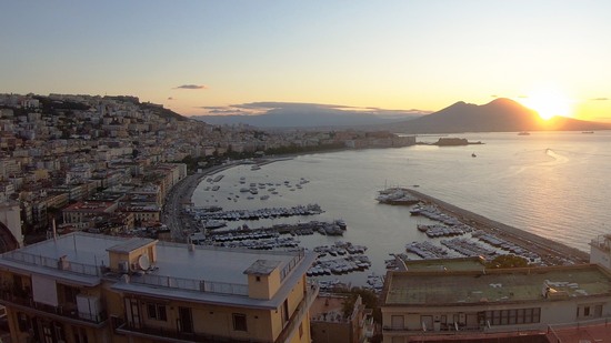 Stadt am Meer mit Hafen und Vulkan im Abendlicht